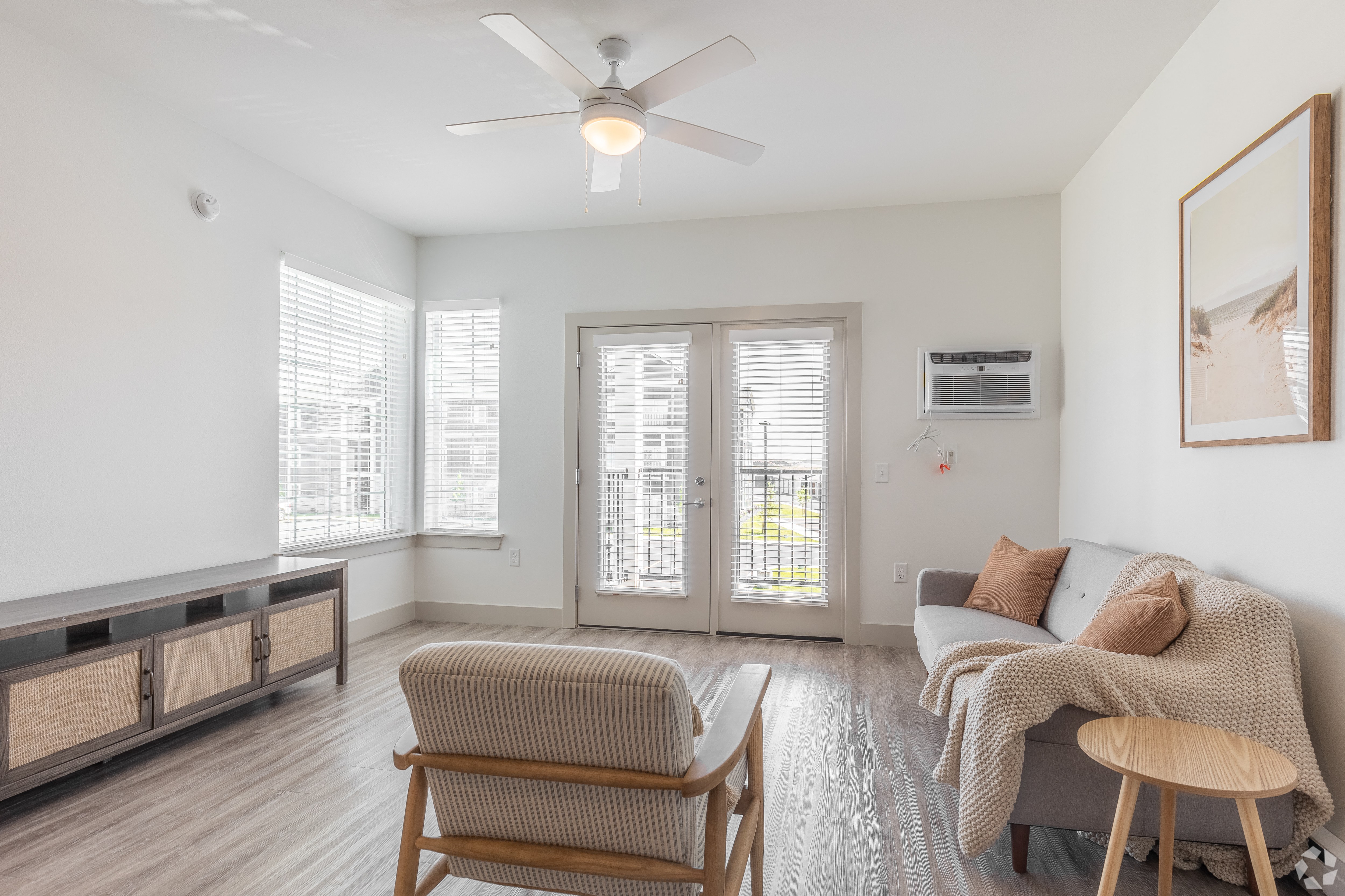 a living room with a couch and a chair and a ceiling fan